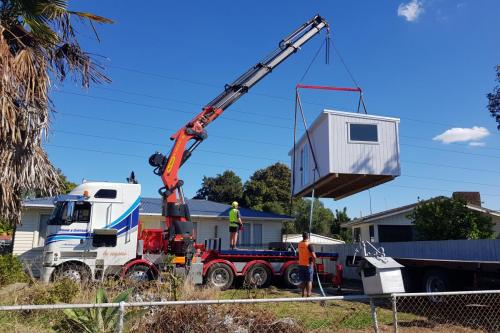 Lifting 3t sleepout over house to backyard in Otara